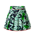 A high-waisted pleated A-line skirt featuring a vibrant green, black, and white batik-style floral and leaf pattern, finished with a thin red piped edge.