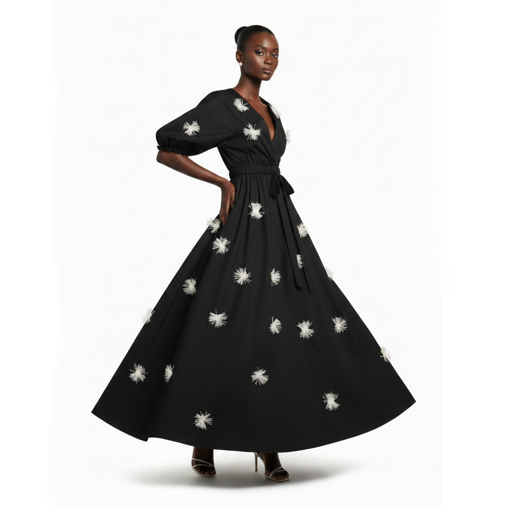 Woman wearing a black dress with white floral patterns on a white background