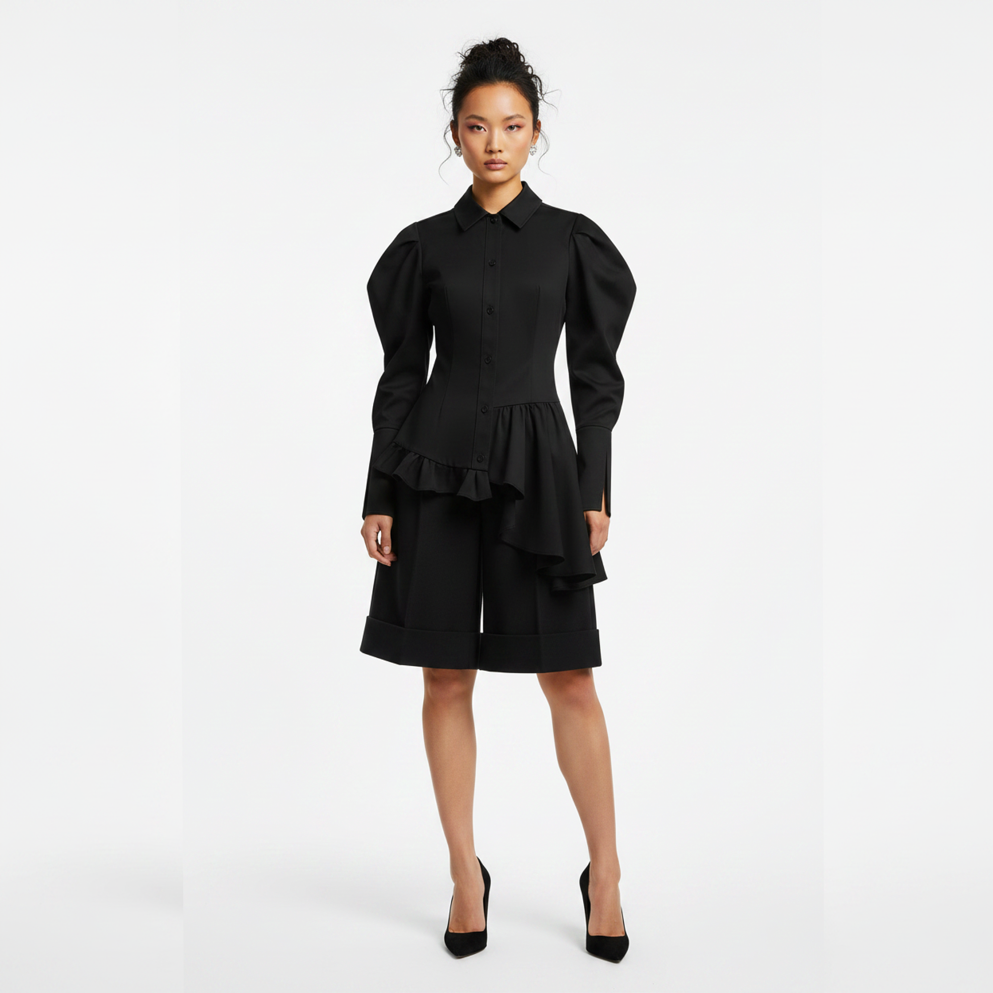 Woman wearing a black dress with ruffled details on a white background