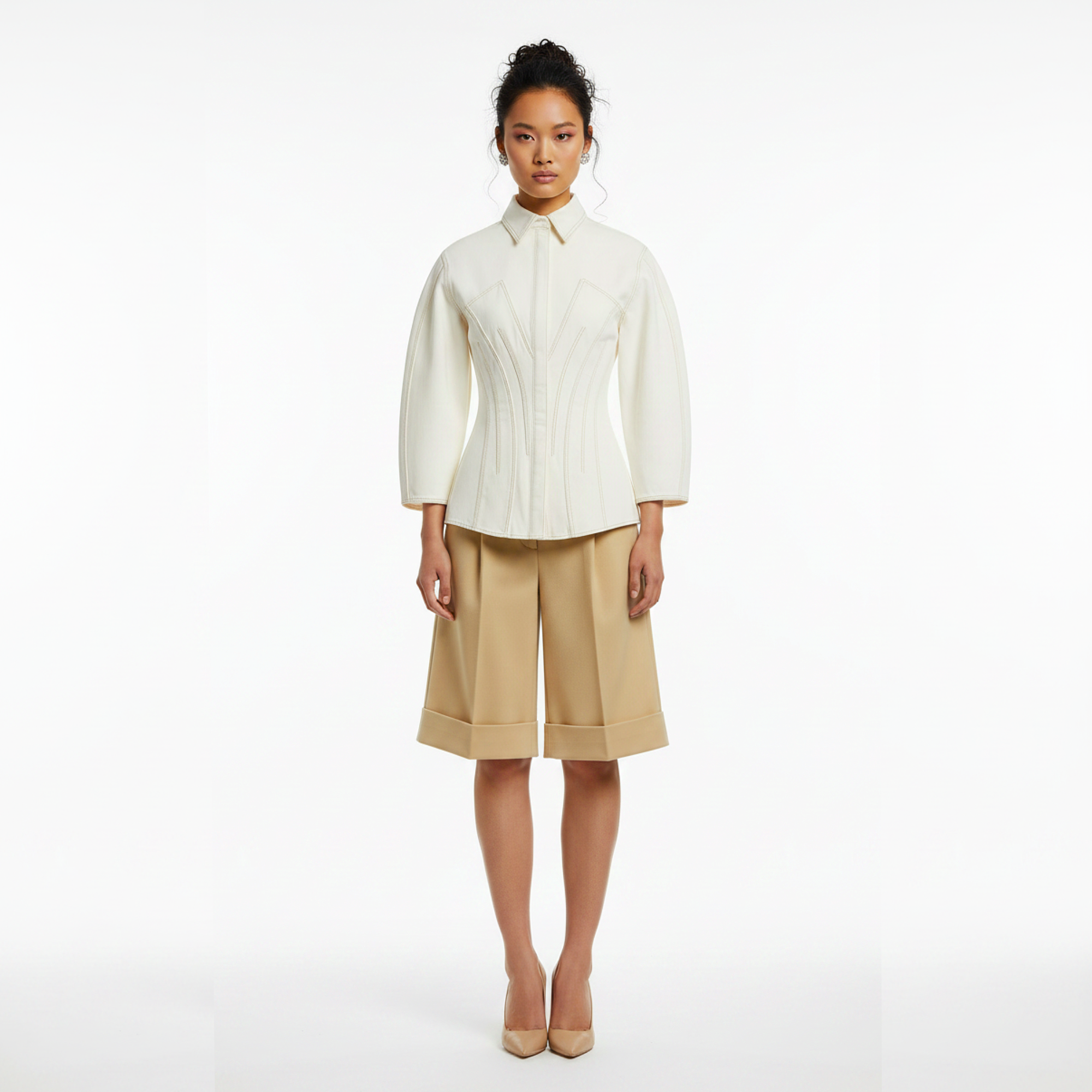 Woman wearing a white blouse and beige shorts on a white background