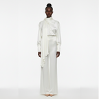 Model wearing a white outfit on a white background
