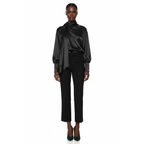 Woman wearing a black satin blouse and pants on a white background