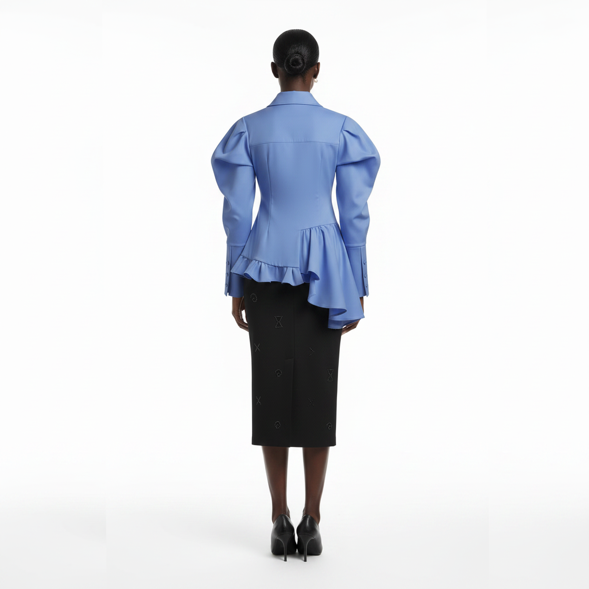 Person wearing a blue blouse with ruffled details and a black skirt on a white background