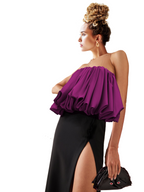 Woman wearing a purple top and black skirt with a white background