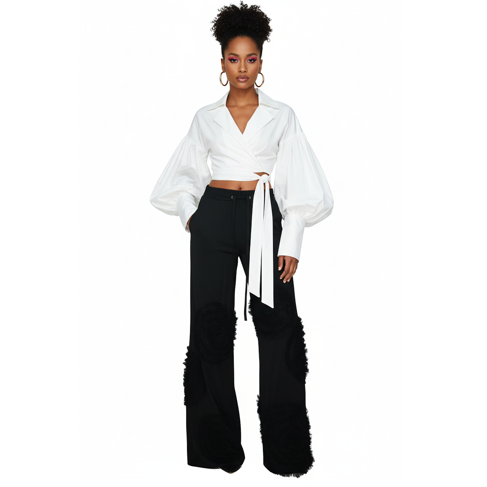 Woman wearing a white blouse with bell sleeves and black pants on a white background