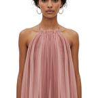 Woman wearing a pink halter neck dress on a white background