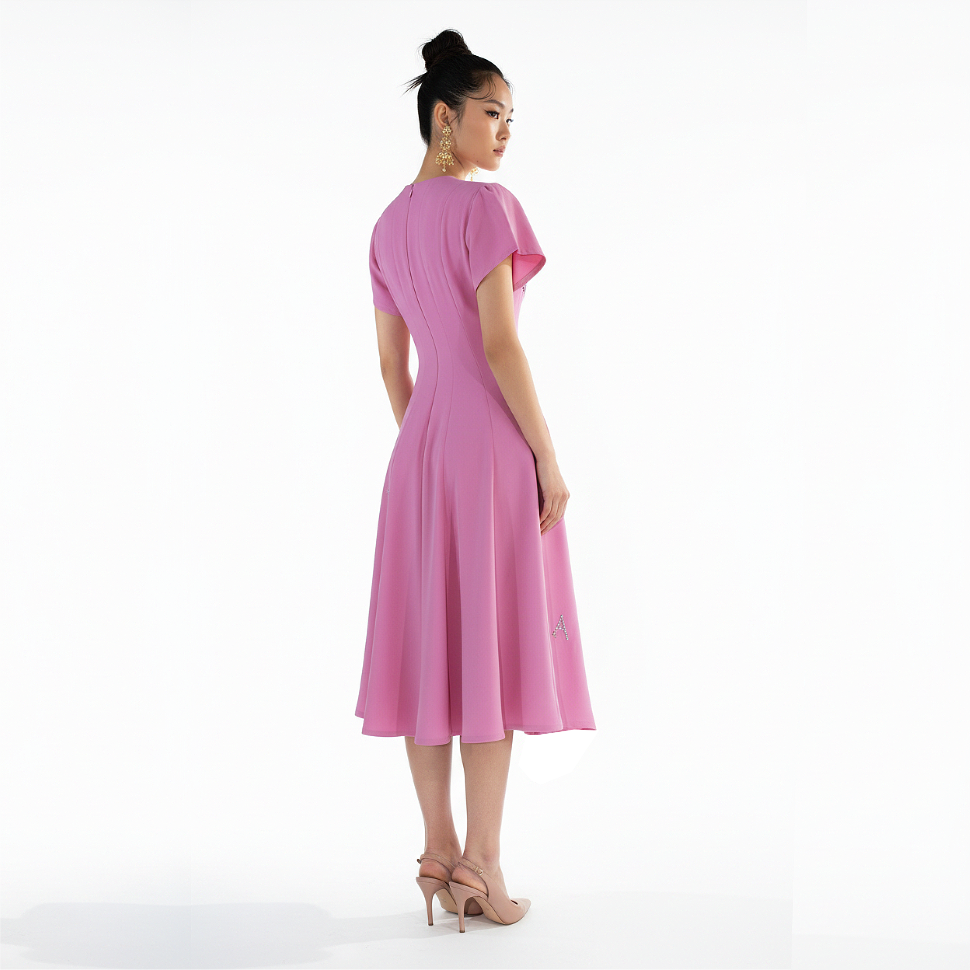 Woman wearing a pink dress on a white background