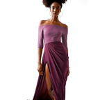 Woman wearing a purple off-shoulder dress with a slit on a white background
