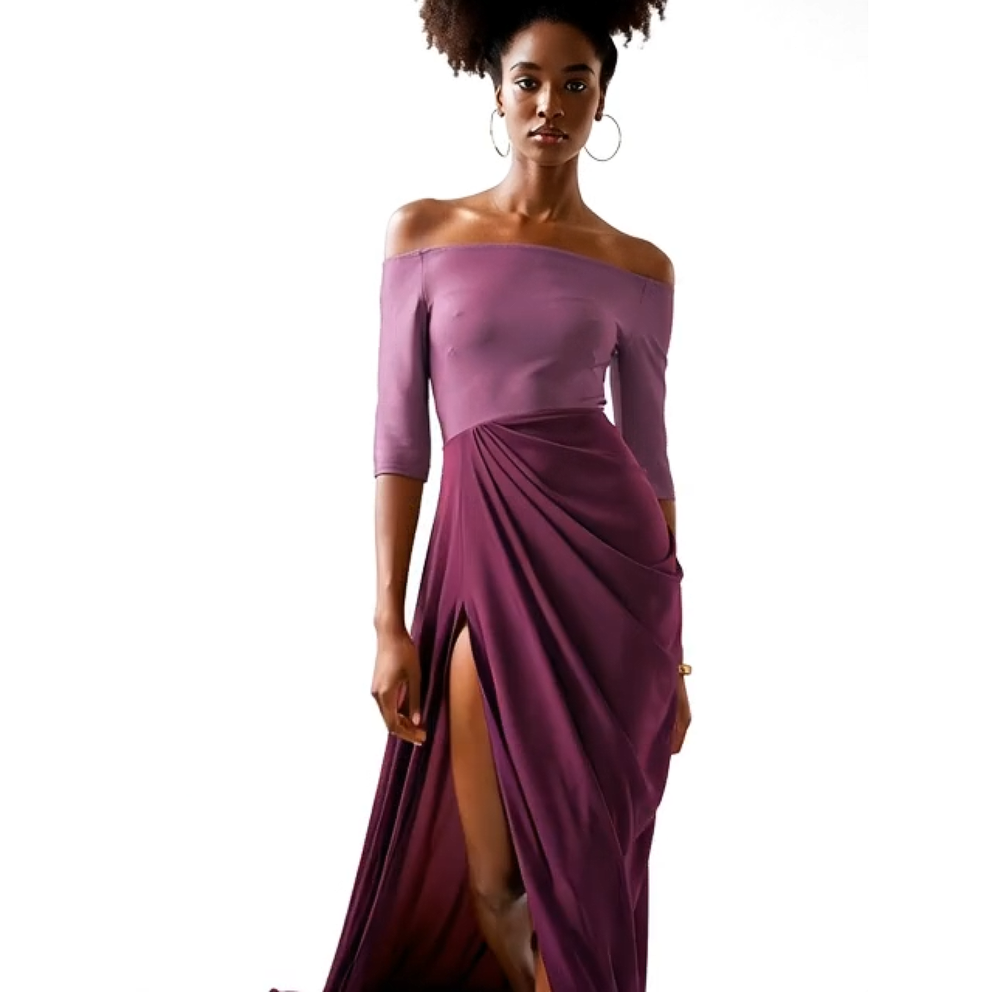 Woman wearing a purple off-shoulder dress with a slit on a white background