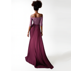Woman wearing a long burgundy off-shoulder dress on a white background