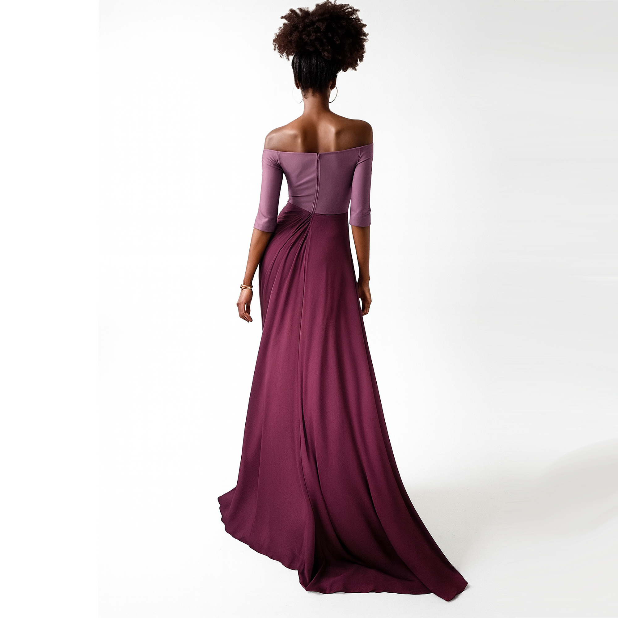 Woman wearing a long burgundy off-shoulder dress on a white background