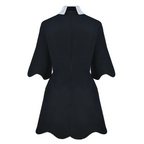 Black dress with white trim on a white background