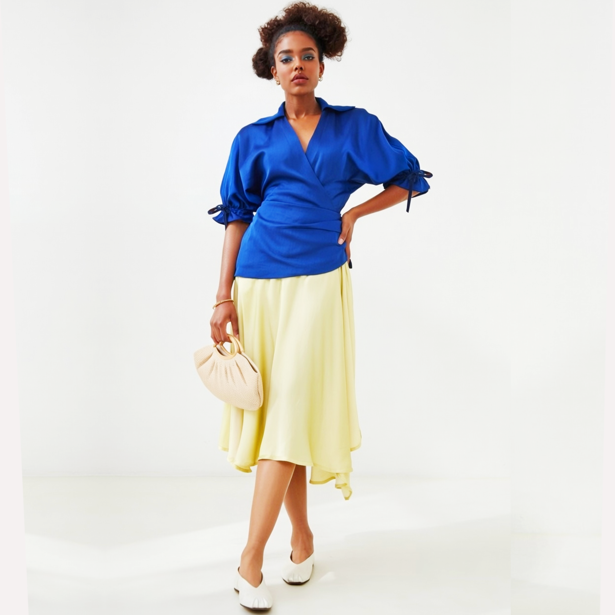 Woman wearing a dress with a  blue top and yellow skirt holding a beige handbag on a white background