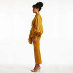 Woman wearing a mustard yellow outfit on a white background