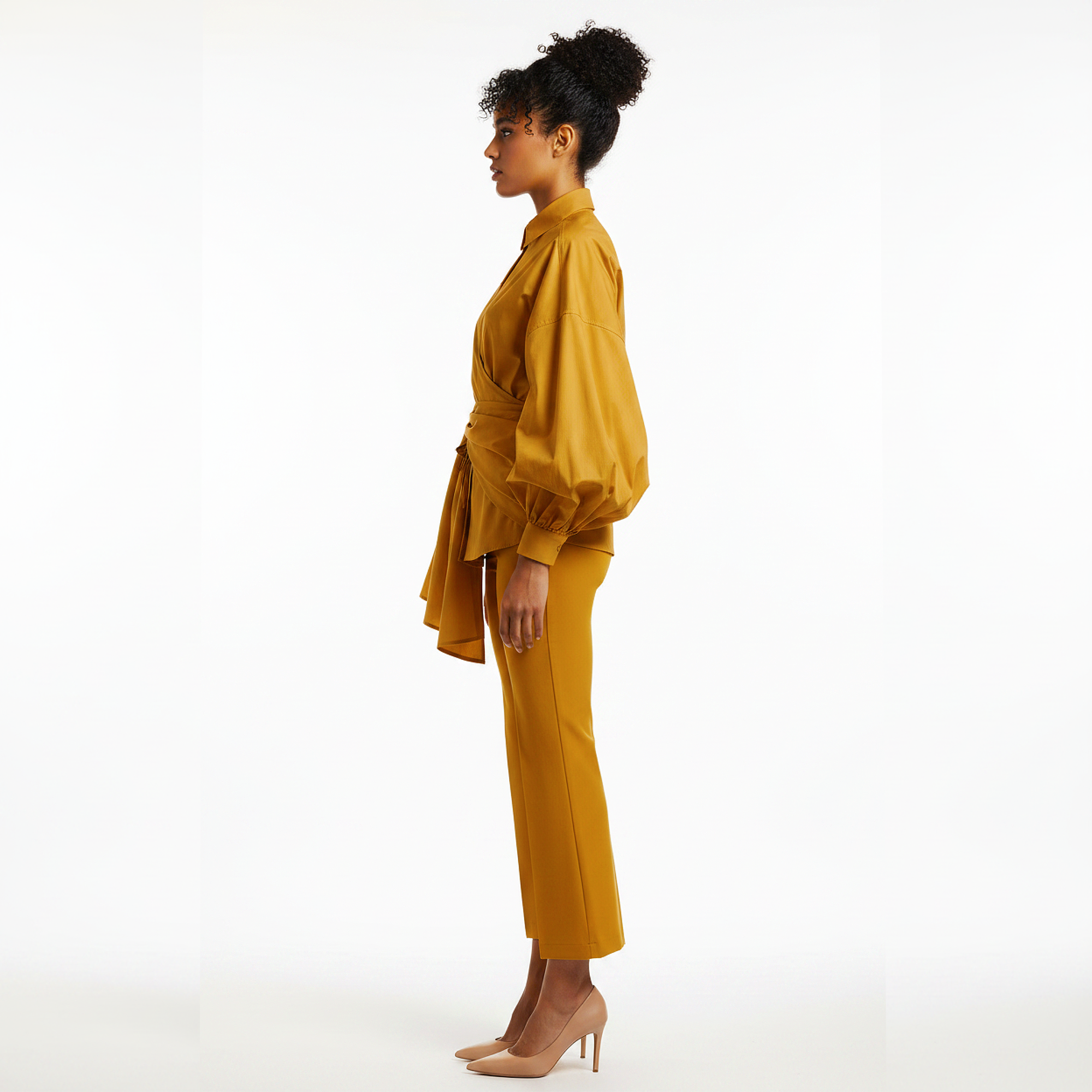 Woman wearing a mustard yellow outfit on a white background