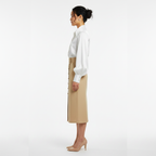 Woman wearing a white blouse and beige skirt on a white background