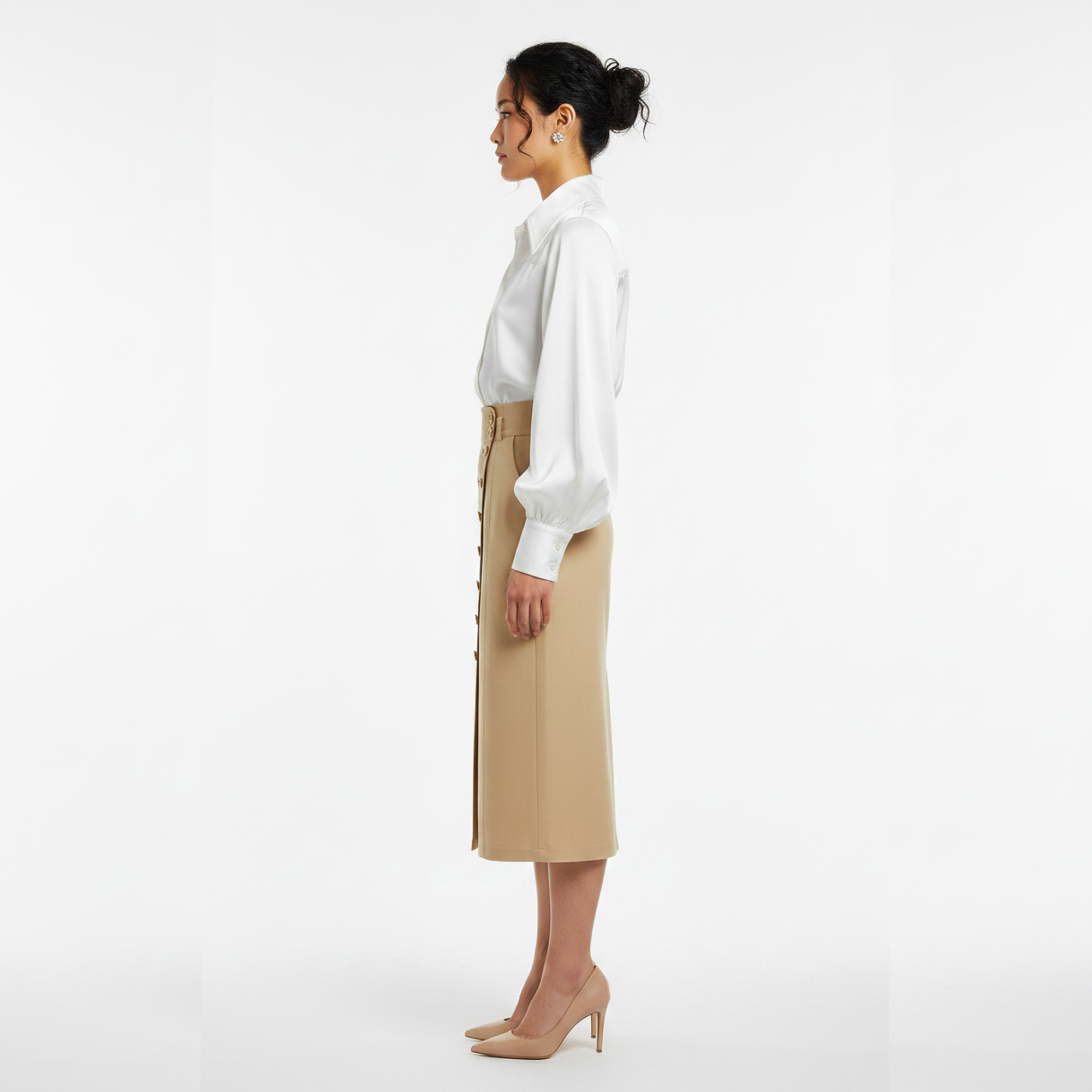 Woman wearing a white blouse and beige skirt on a white background
