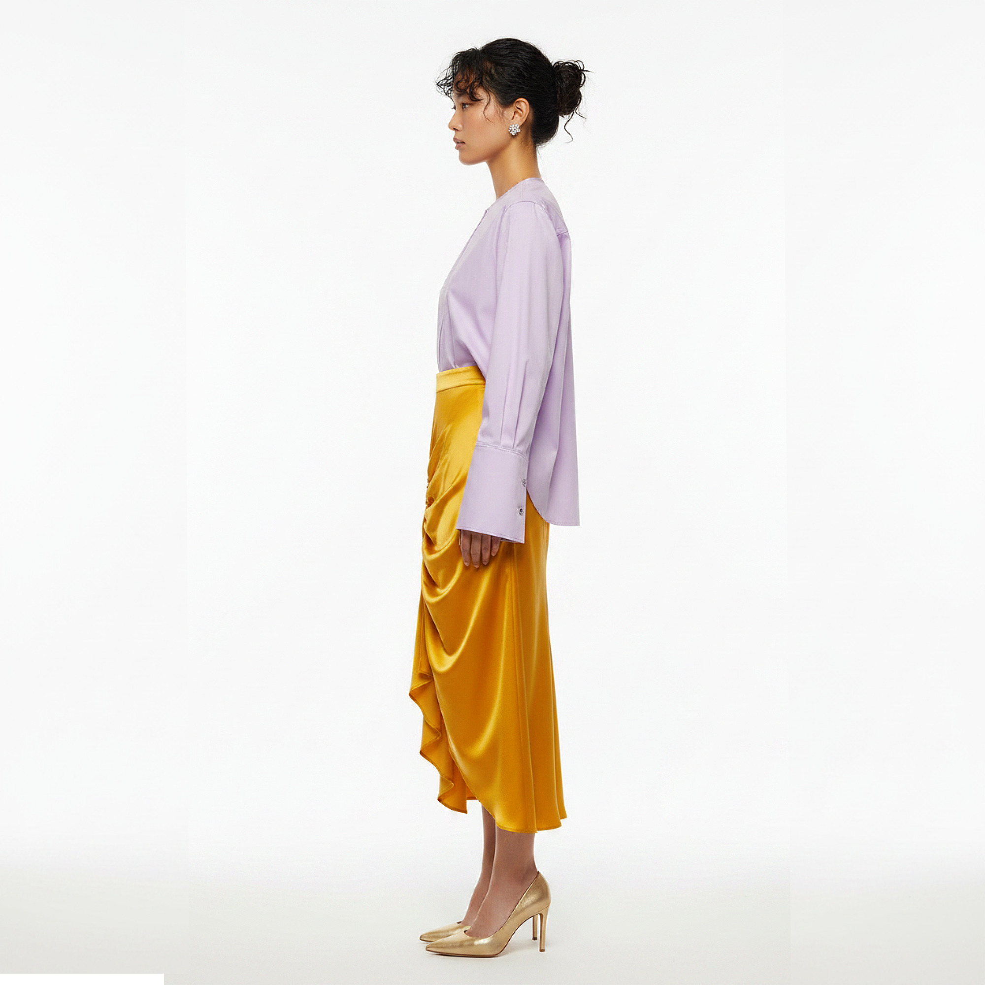 Woman wearing a light purple top and yellow skirt on a white background