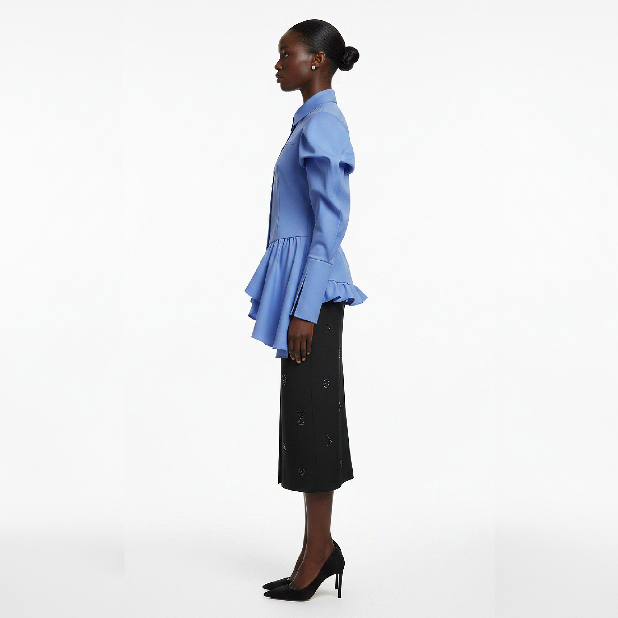 Woman wearing a blue peplum top and black skirt on a white background