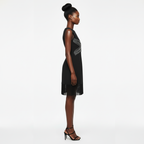 Woman wearing a black dress with a subtle pattern on a white background