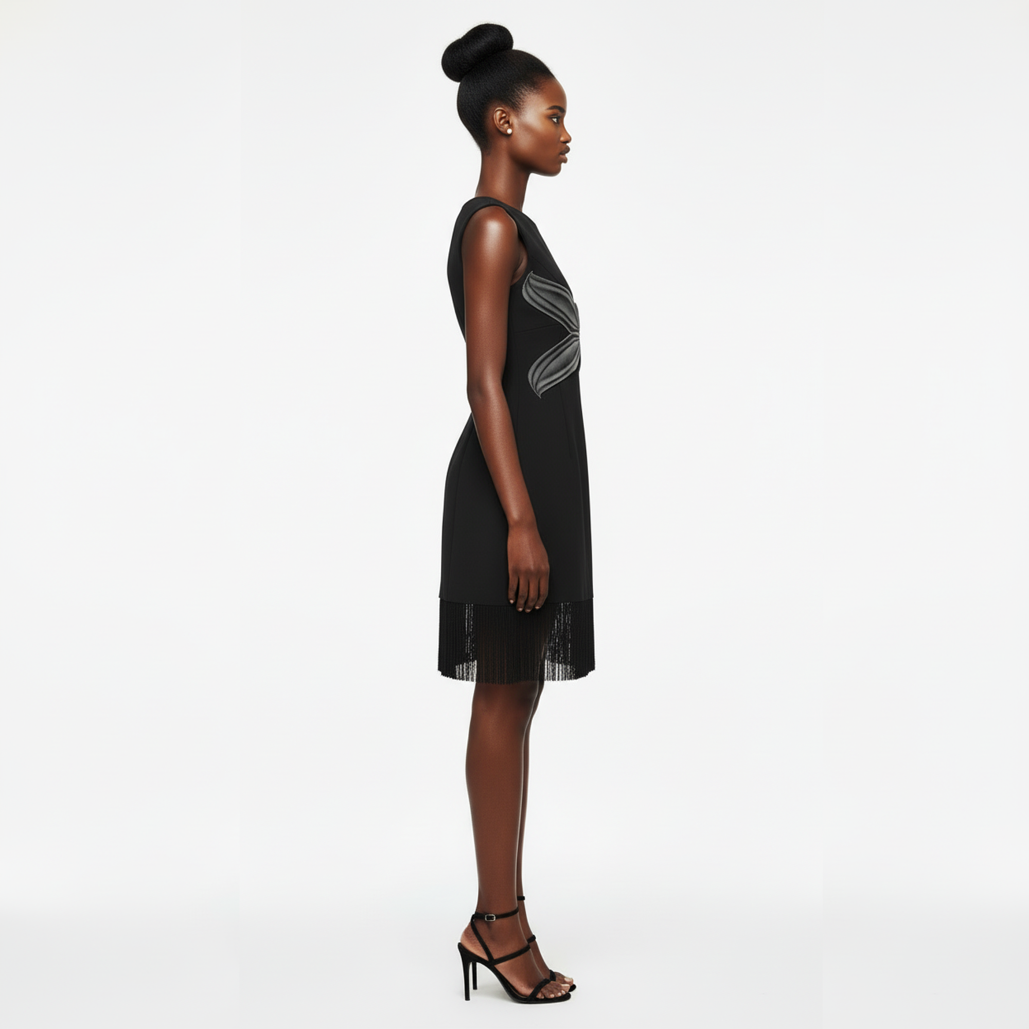 Woman wearing a black dress with a subtle pattern on a white background