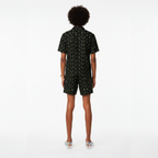 Person wearing a black patterned romper on a white background
