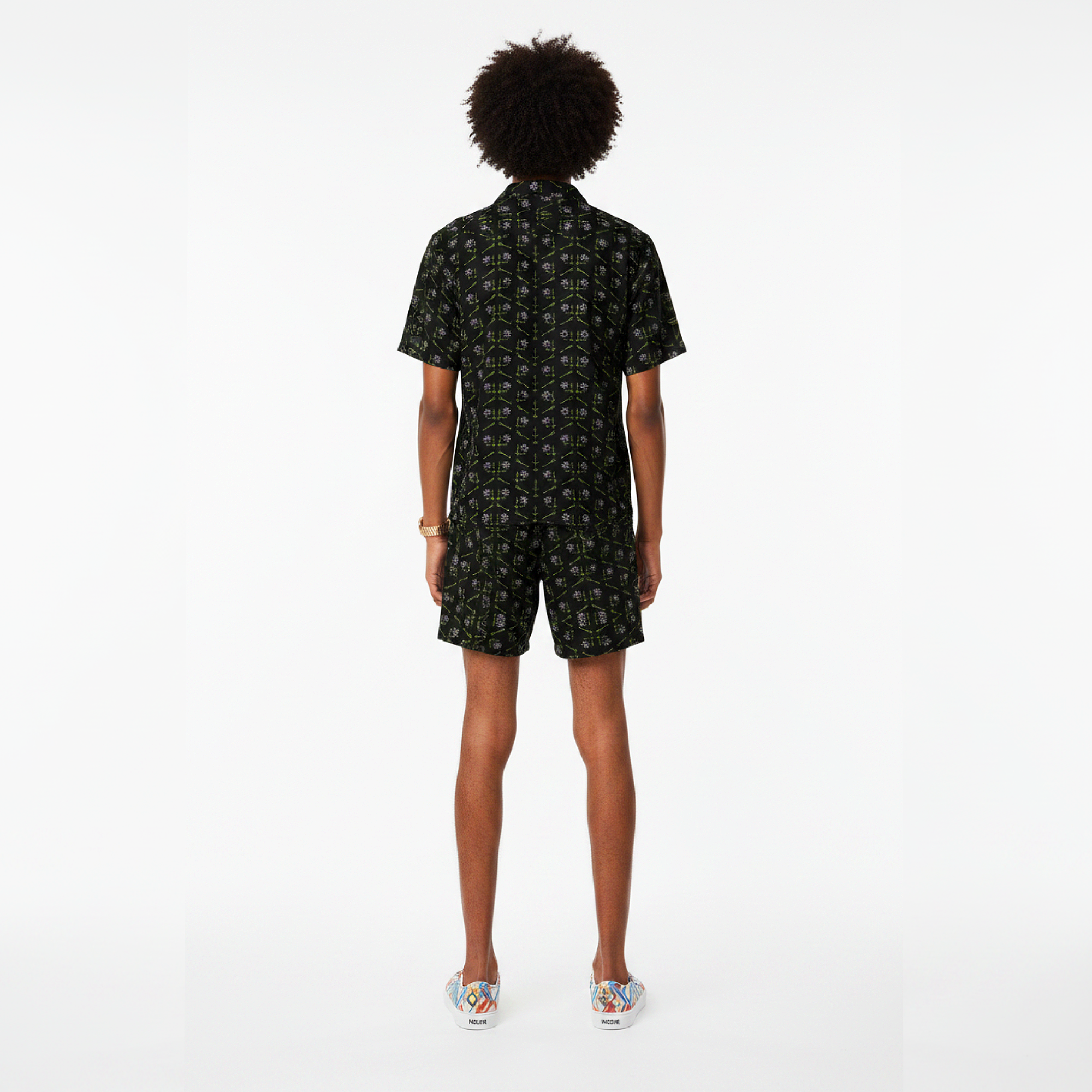 Person wearing a black patterned romper on a white background