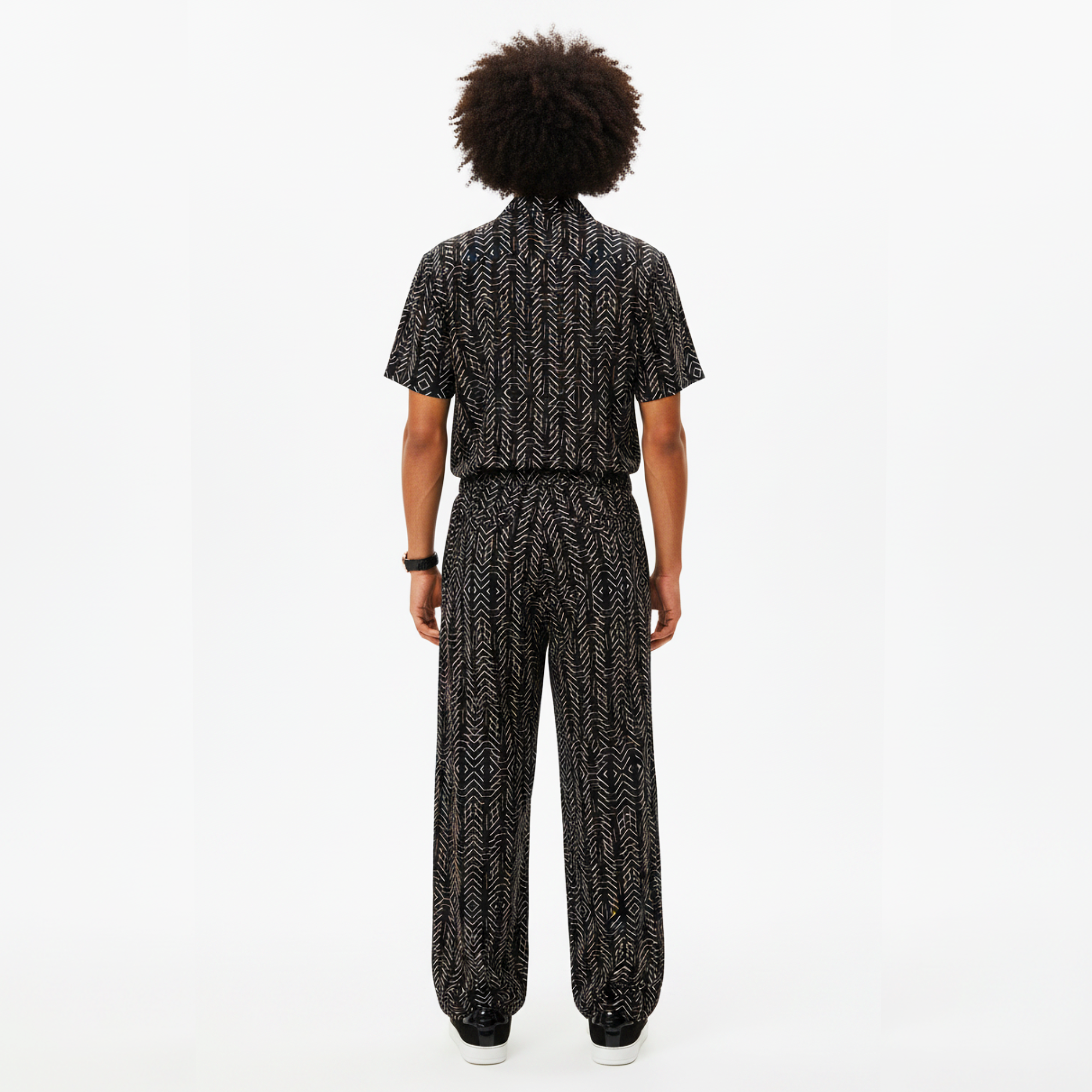 Person wearing a black and white patterned outfit on a white background