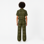 Person wearing a black and yellow patterned jumpsuit on a white background