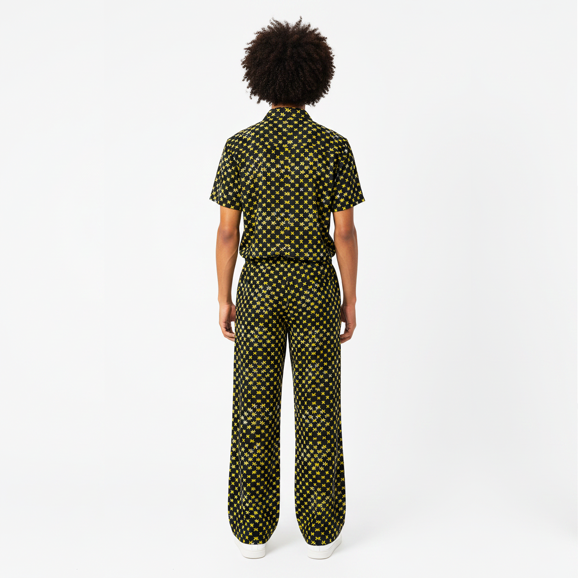 Person wearing a black and yellow patterned jumpsuit on a white background