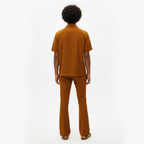 Person wearing a brown outfit on a white background