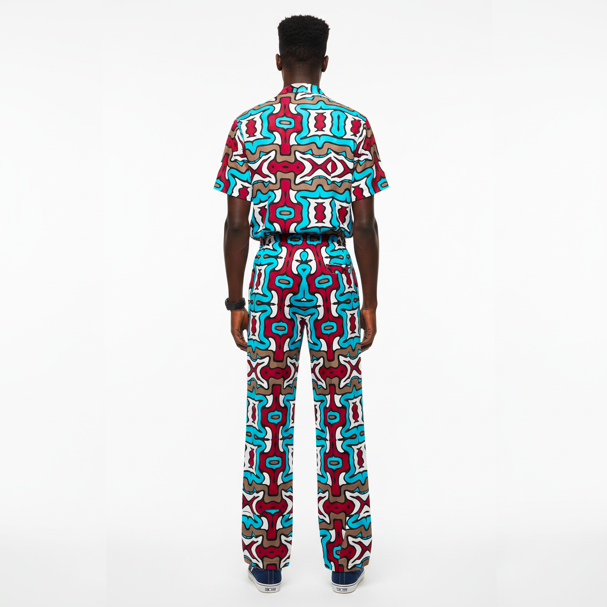 Person wearing a colorful patterned outfit on a white background