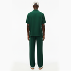 Person wearing a green outfit with a white cap on a white background