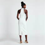 Woman wearing a white halter neck dress on a plain background