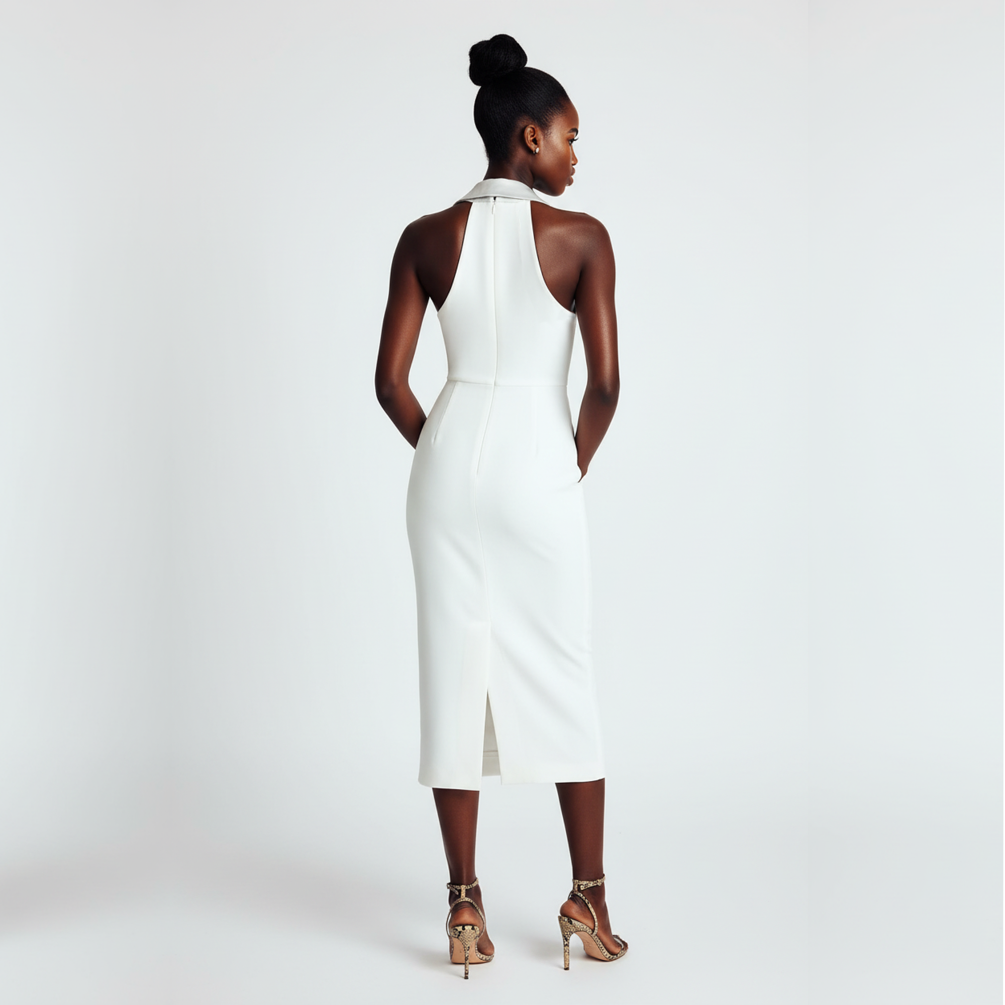 Woman wearing a white halter neck dress on a plain background