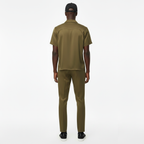 Person wearing an olive green outfit on a white background