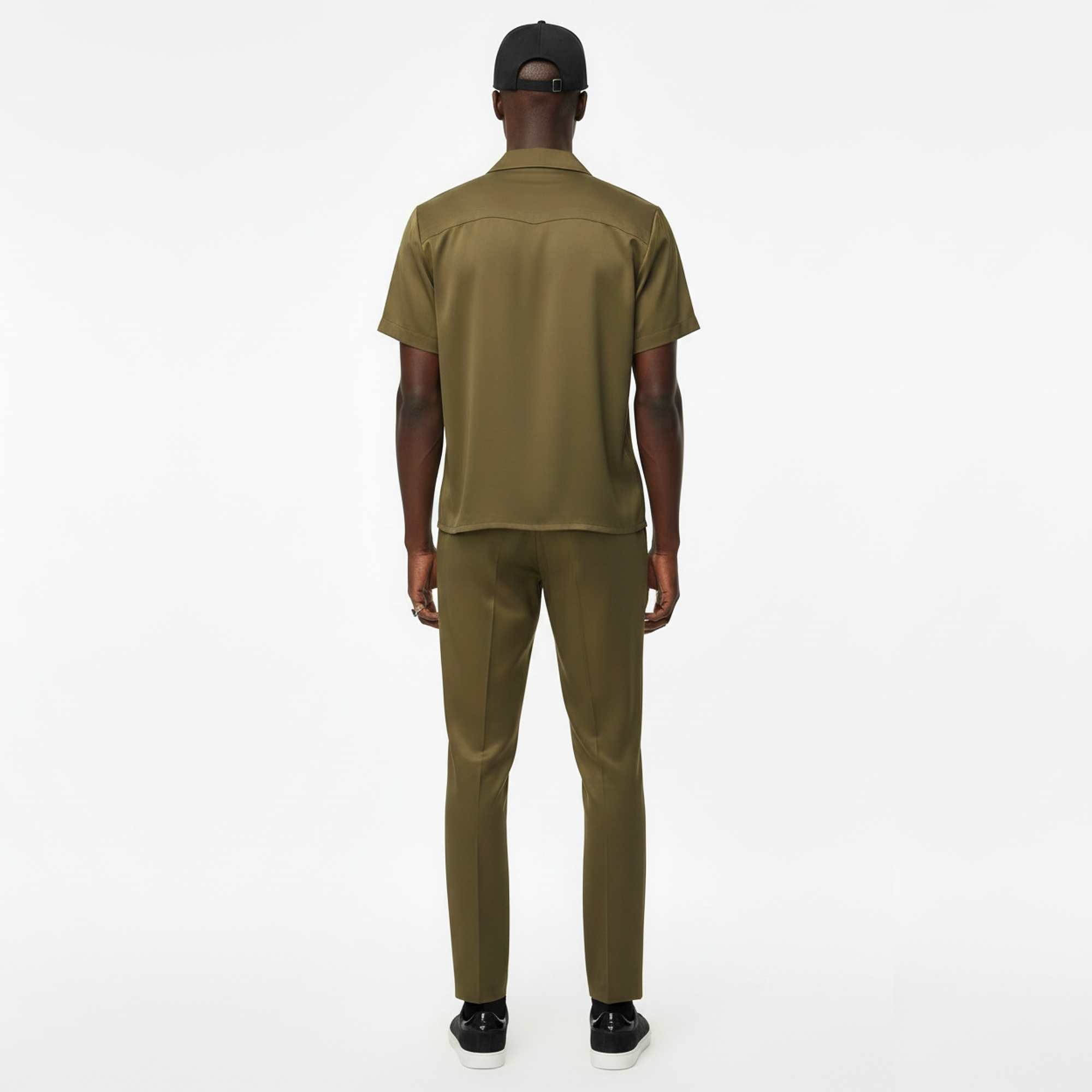Person wearing an olive green outfit on a white background