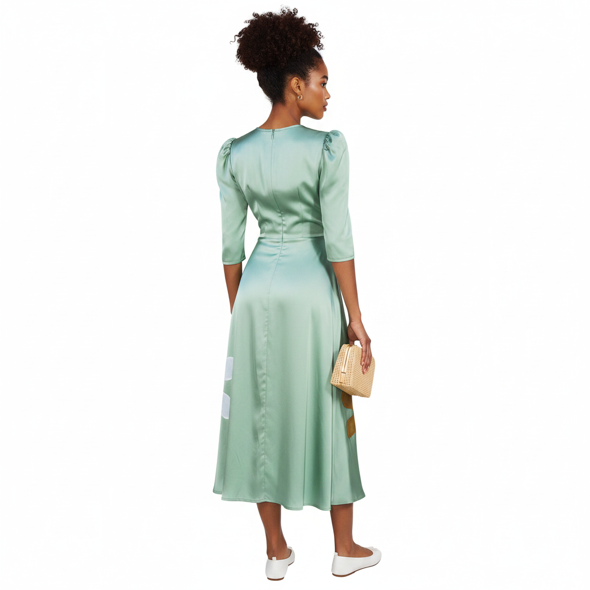 Woman wearing a green dress with floral designs against a white background