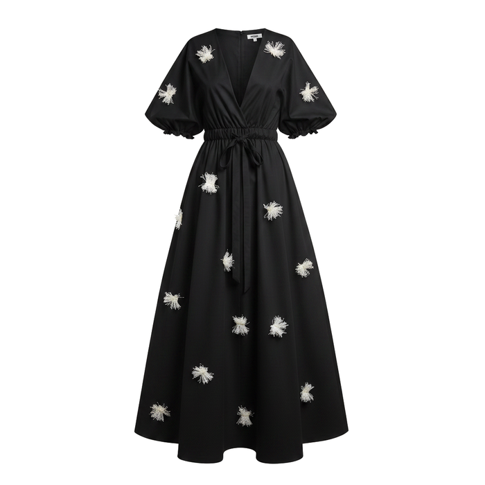 Black dress with white floral embellishments on a white background