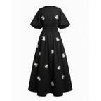 Black dress with white floral embellishments on a white background