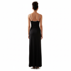 Woman wearing a black evening gown with thin straps on a white background