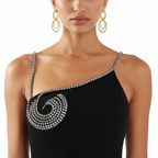 Black one-shoulder dress with intricate silver detailing worn by a model on a white background