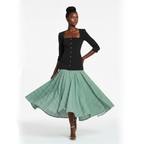 Woman wearing a black top and green checkered skirt on a white background
