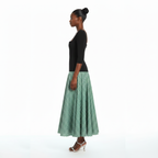 Woman wearing a black top and green checkered skirt on a white background