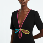 Black dress with colorful neckline design on a model against a white background