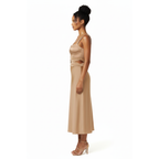 Woman wearing a beige dress with cut-out details on a white background