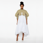 Woman wearing a beige jacket over a white dress on a white background