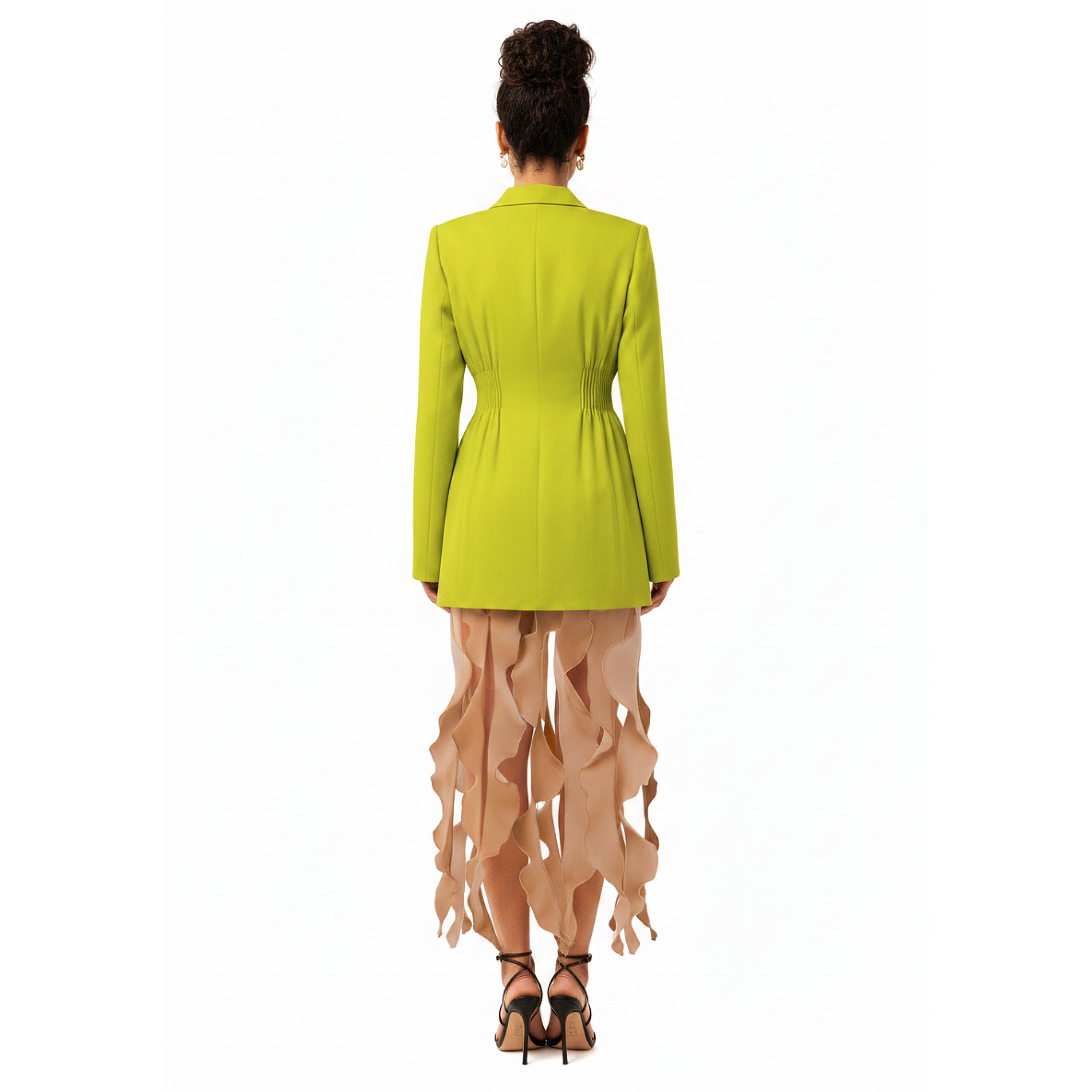 Person wearing a bright green blazer and beige pants on a white background