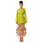 Woman wearing a bright green blazer over a sheer dress on a white background
