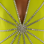Close-up of a lime green dress with a starburst pattern of rhinestones.